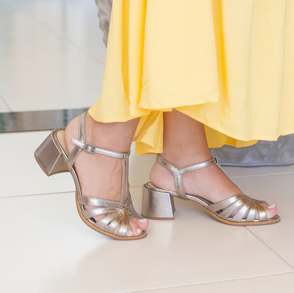 A modelo está usando a Sandália Retrô em Couro de Salto Médio Thalia Onix